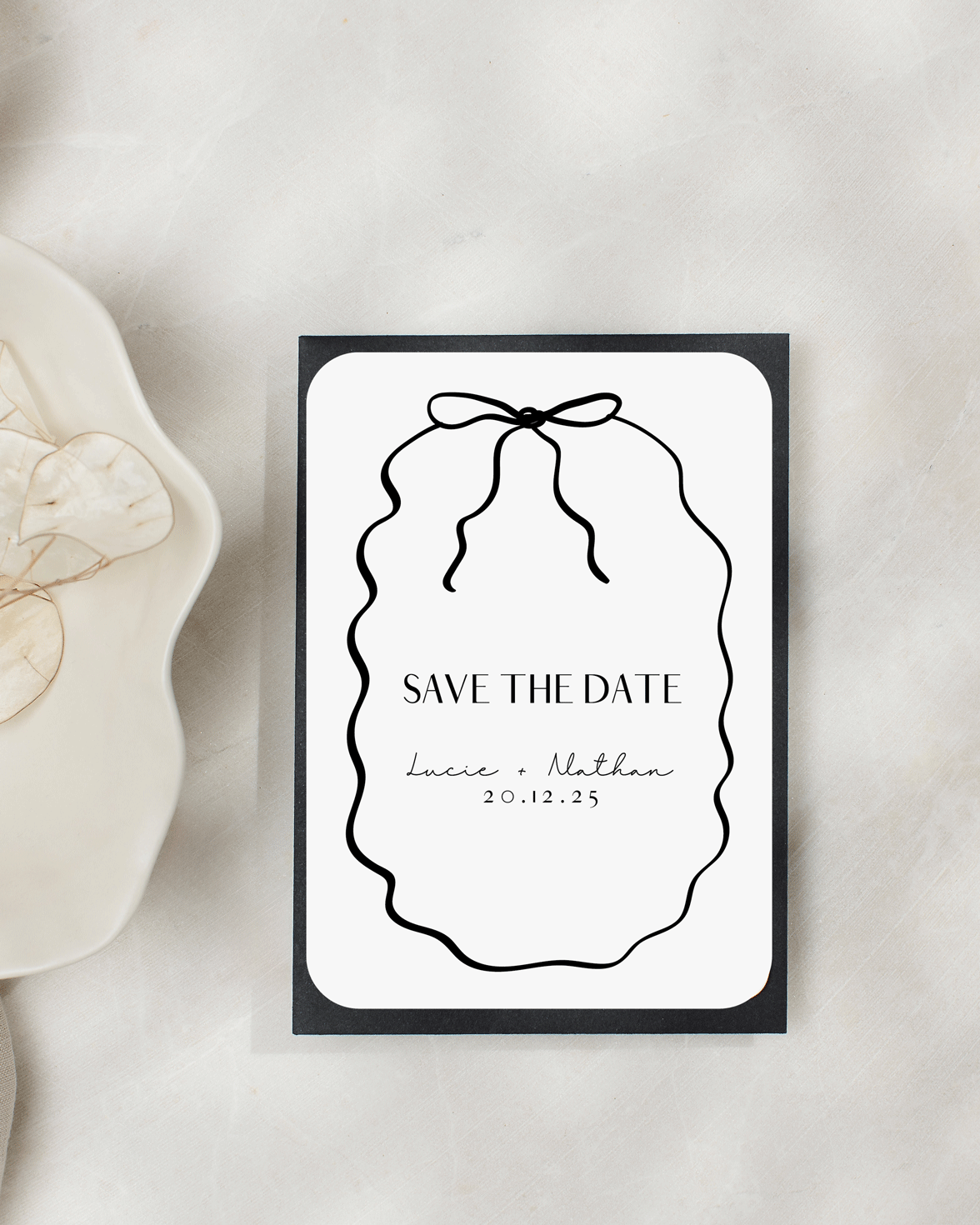 White and black save the date with hand drawn squiggly line border and bow