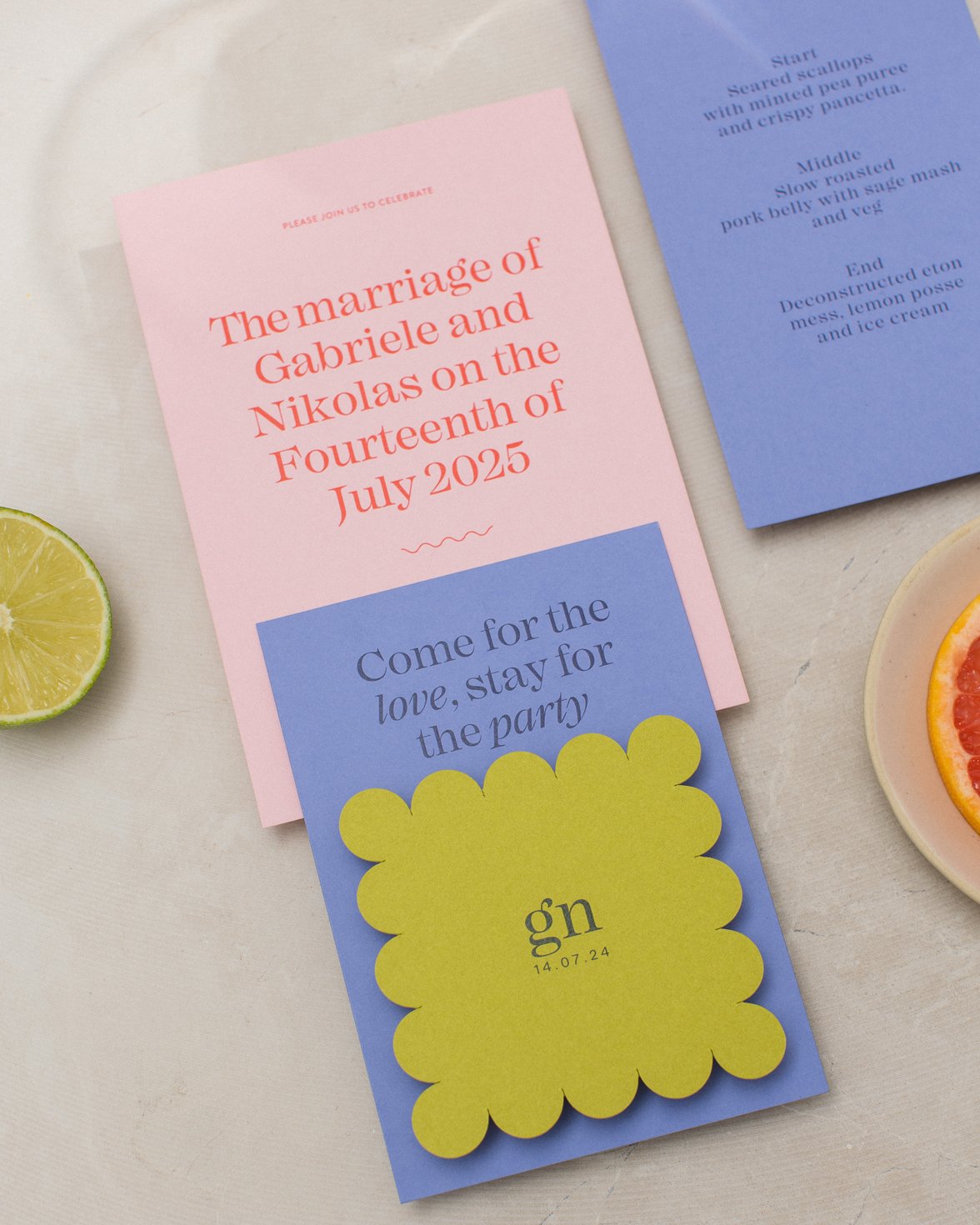 Pink and red wedding invitation bundle with modern bold typography. Purple wedding details card and citrus green name card/RSVP with scalloped edges.