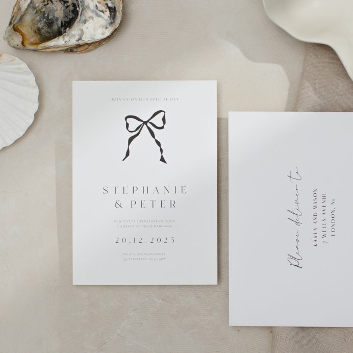 White and black wedding invitation with hand drawn bow. White address envelope in script font