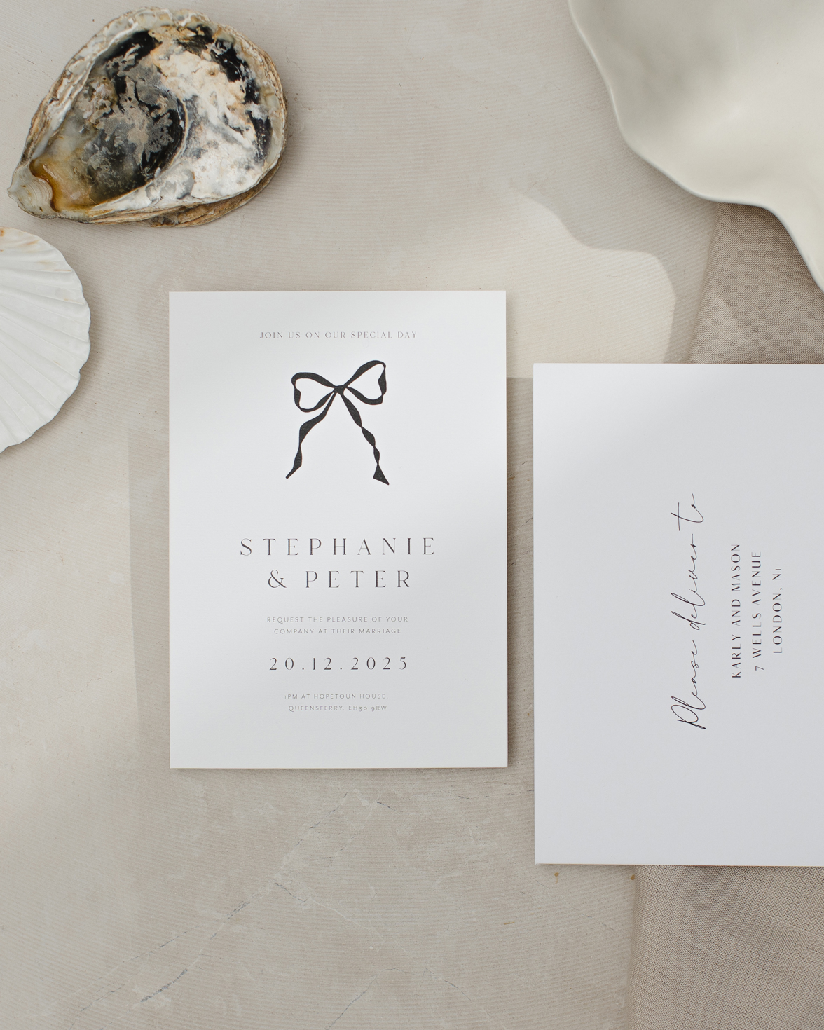 White and black wedding invitation with hand drawn bow. White address envelope in script font