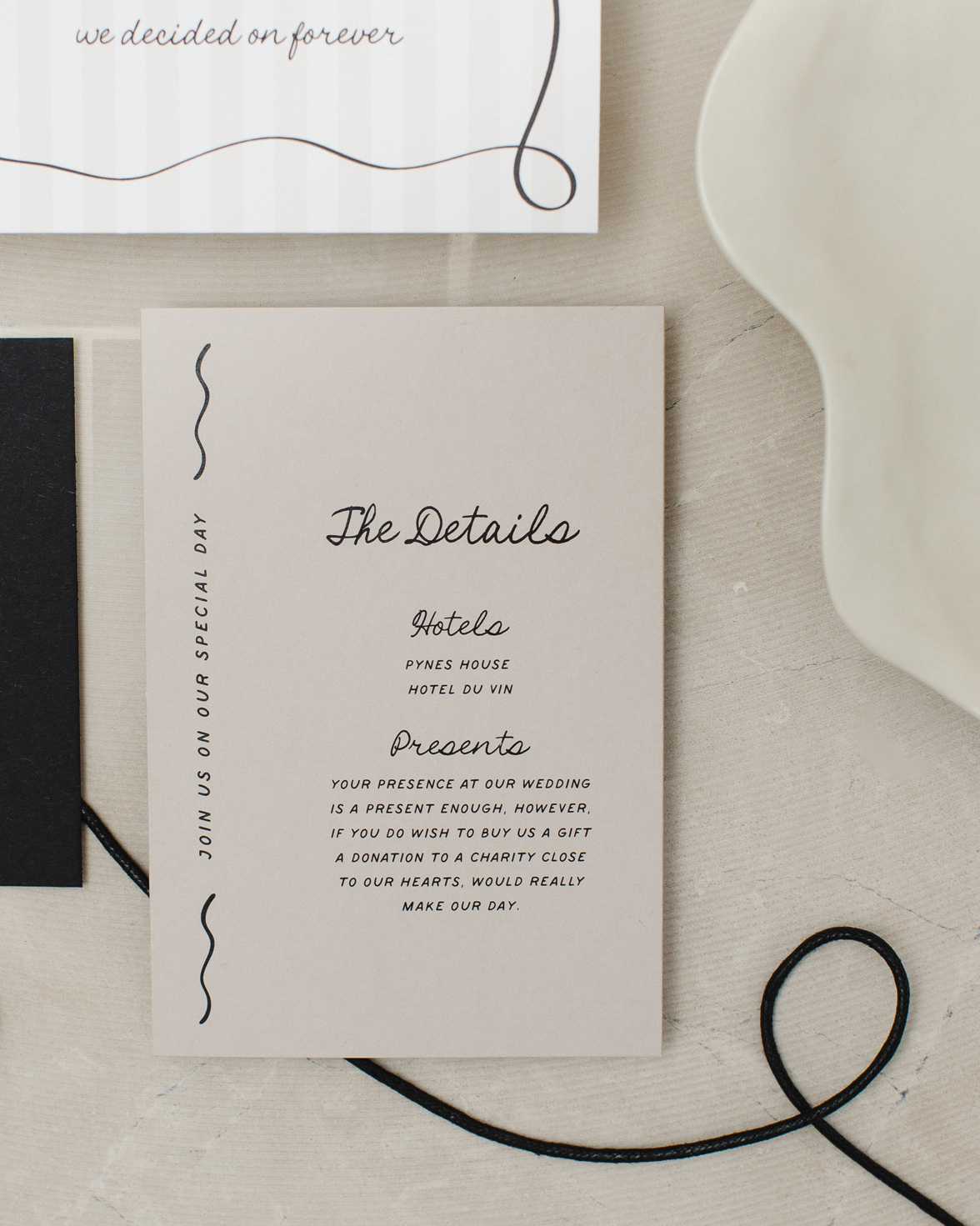 Stone coloured wedding details card with squiggly line