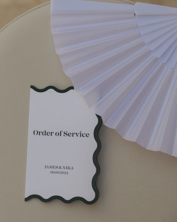 White wedding order of service with black border. Wavy scalloped cut edge.