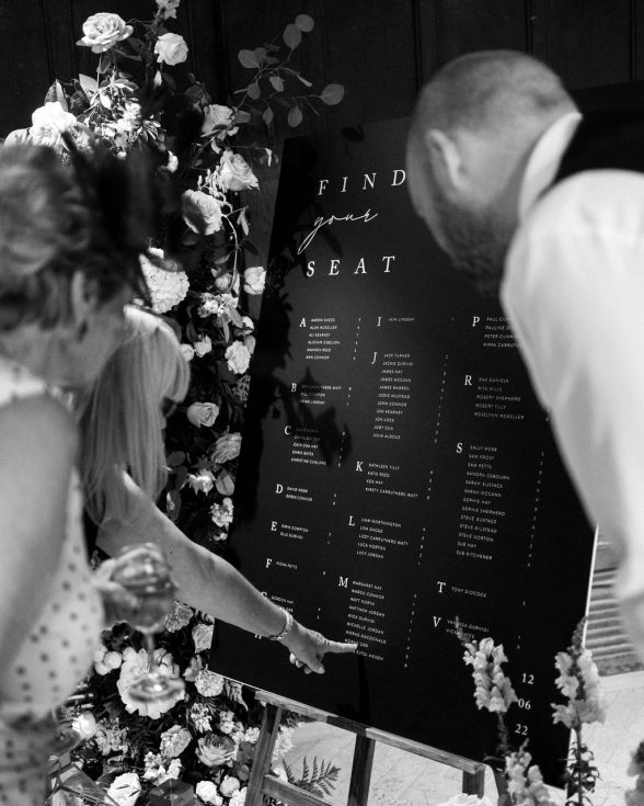 Wedding guest looking at black and white table plan